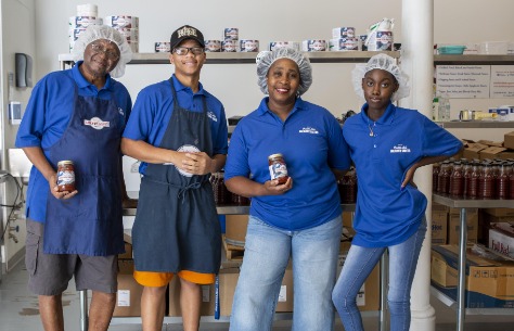 workers in blue shirts and hairnets standing in a store