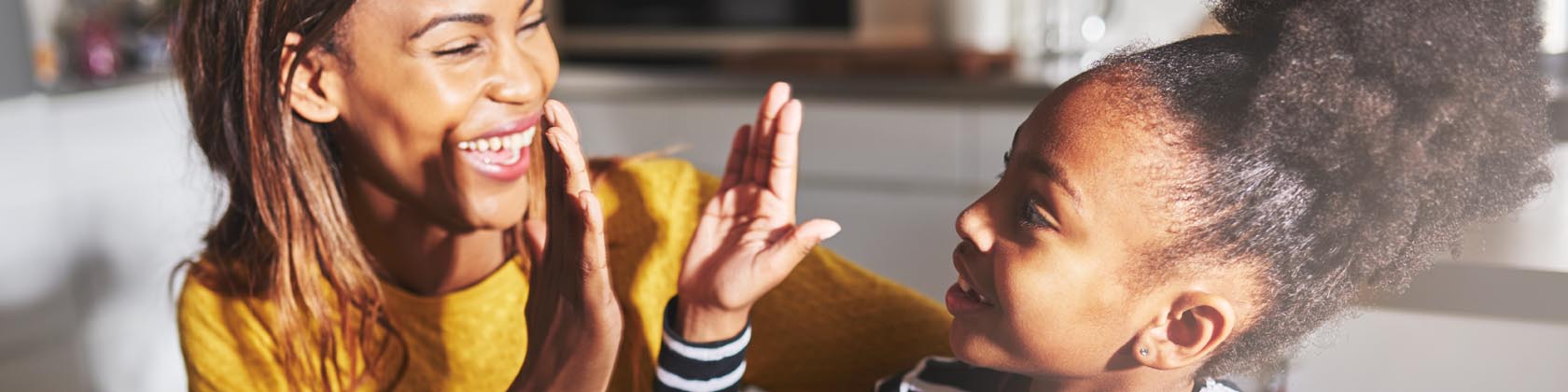 Woman and girl smiling and high-fiving