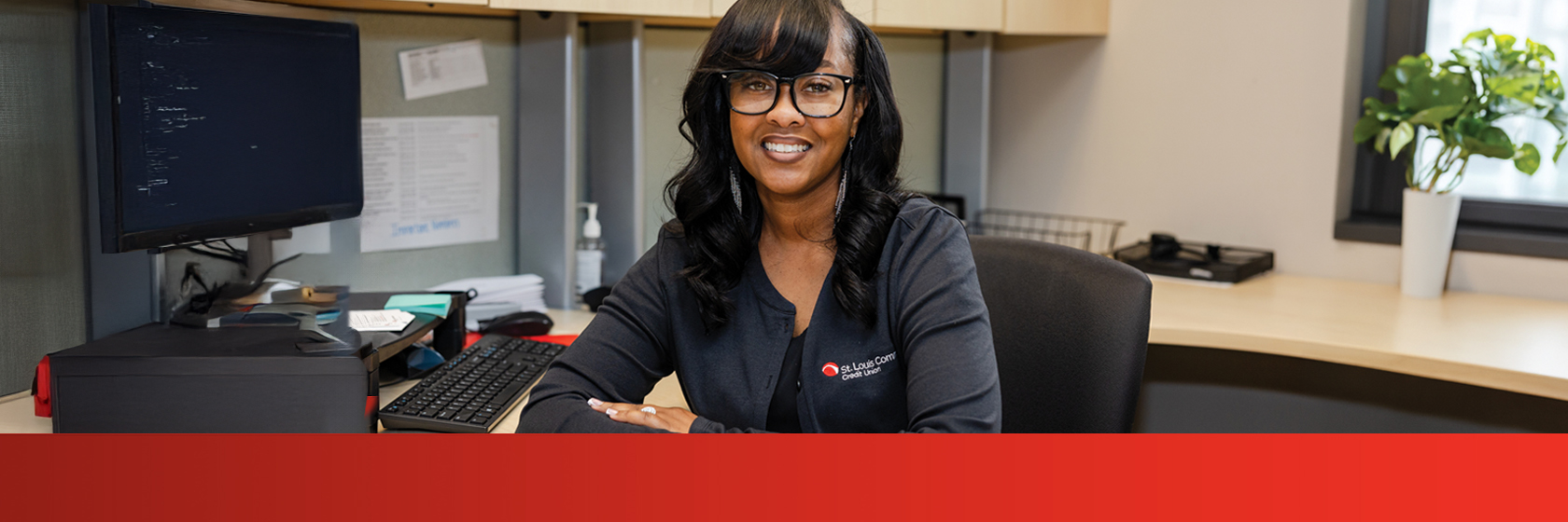 Image of a woman in glasses smiling above a red banner