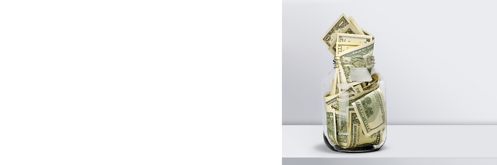 Image of a jar stuffed with money sitting on the counter