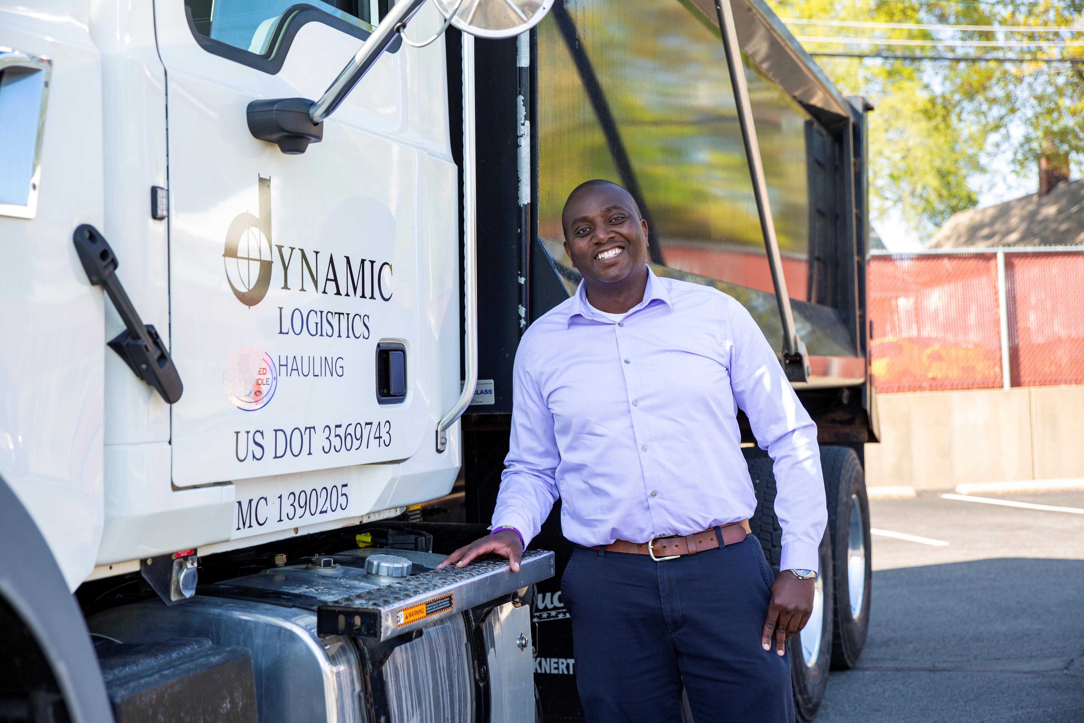 man posing next to a logistics truck