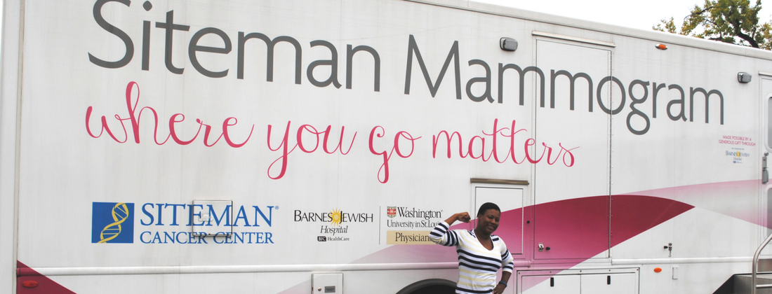 Woman smiling and flexing one arm in front of Siteman Cancer Center bus